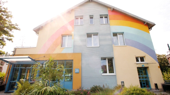 Außenansicht vom Kinderhospiz Regenbogenland. Haus mit Regenbogenanstrich