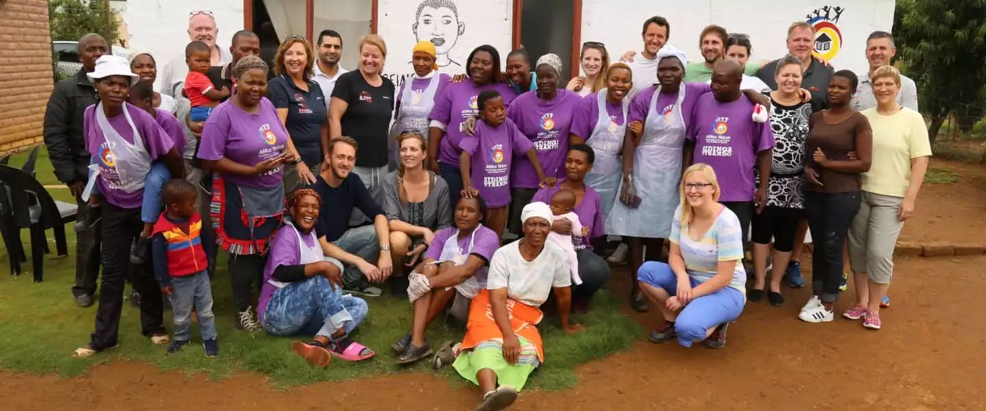 en.Gruppenfoto mit den Kindern von Afrika Tikkun und dem GIVING BACK Team